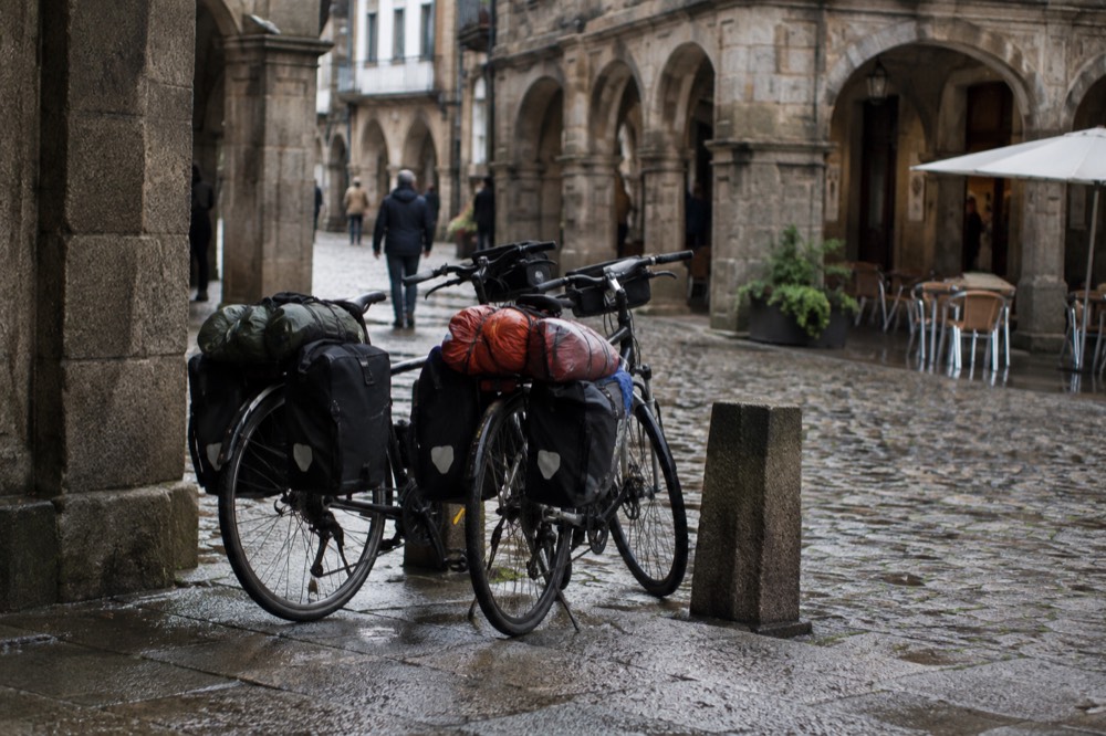 Bicycles loaded with touring gear parked on a cobbled square in the old town of Santiago de Compostela