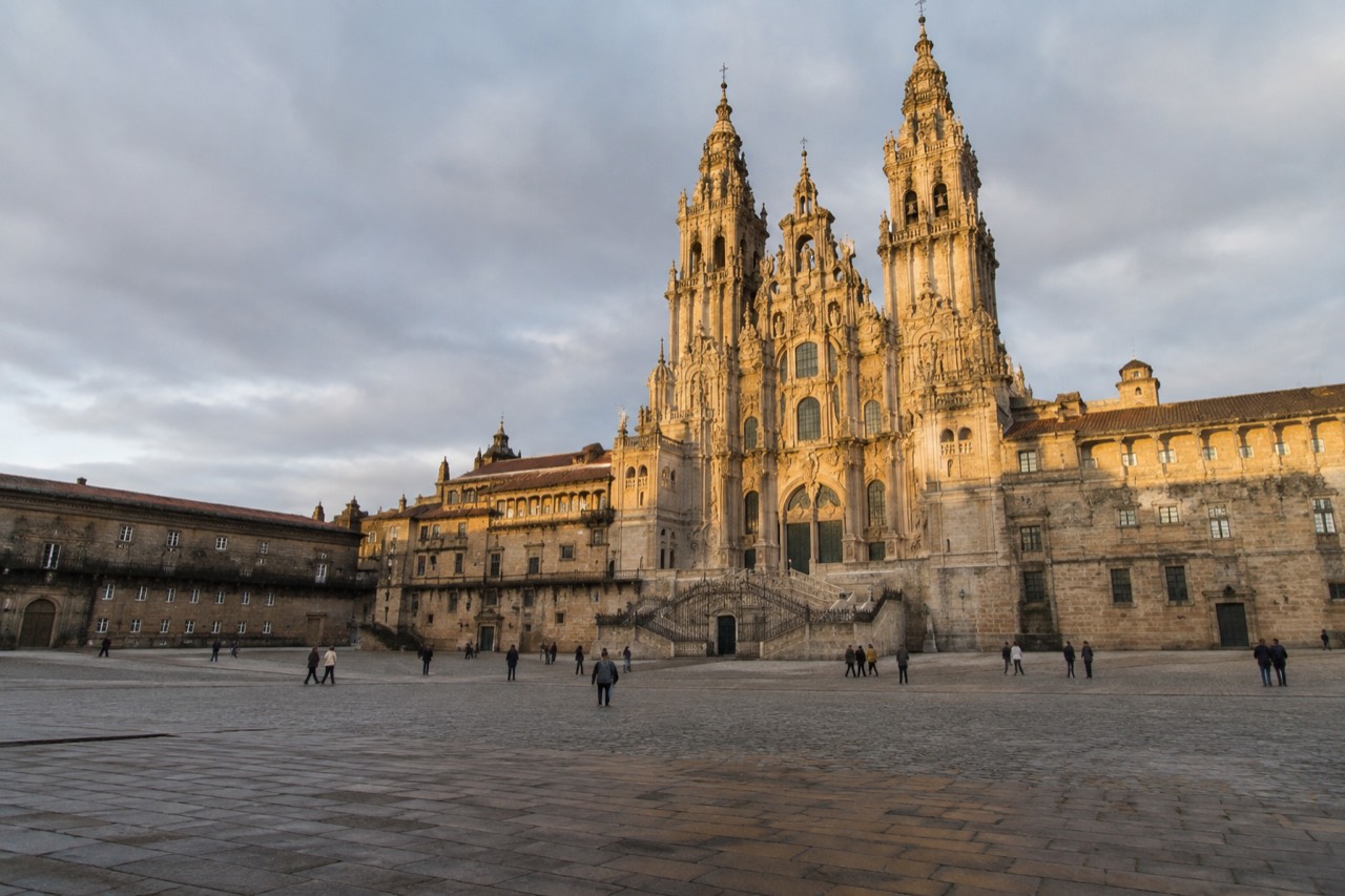 The baroque facade of Santiago de Compostela Cathedral rising above Praza do Obradoiro in golden evening light