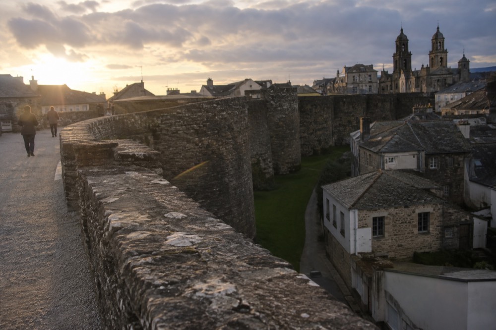 Granite arches and honey-stone buildings in the old town of Lugo, Galicia, Spain