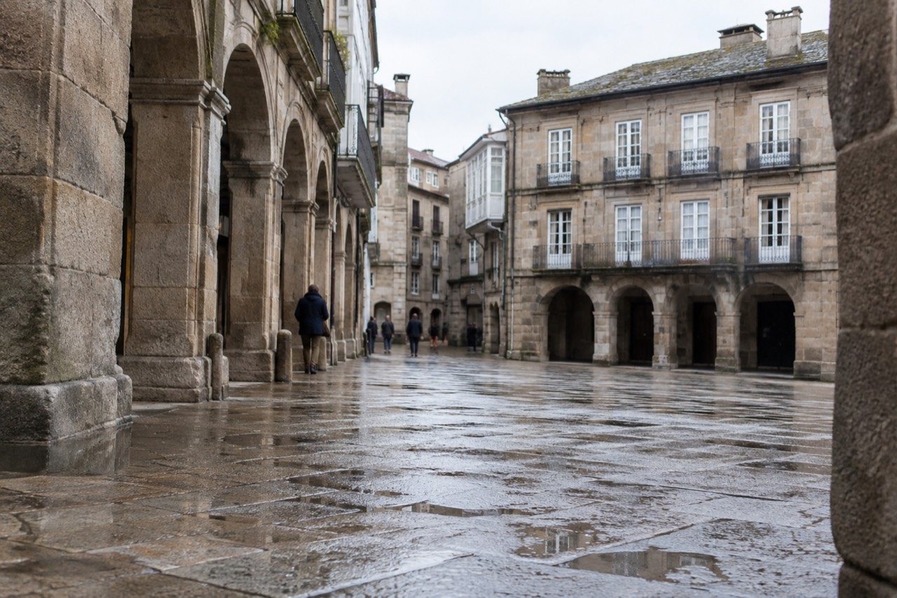 Granite arcades and historic buildings around a stone square in a Galician old town