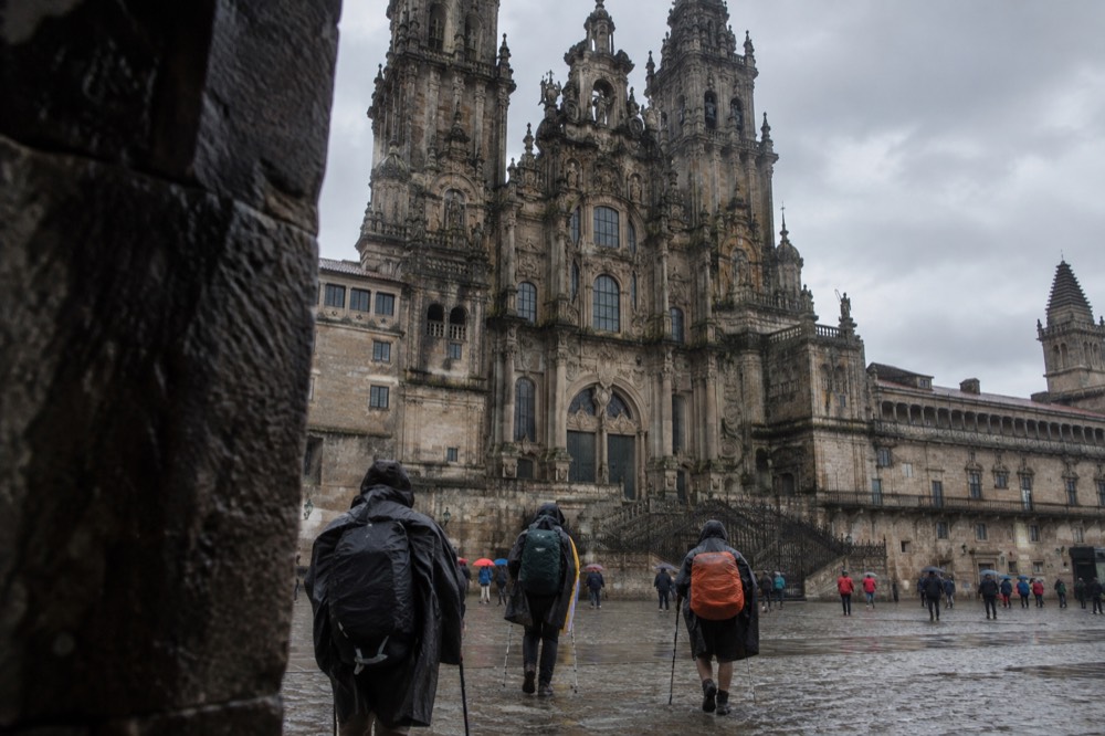 Pilgrims arriving at the Cathedral in Santiago de Compostela on a rainy day