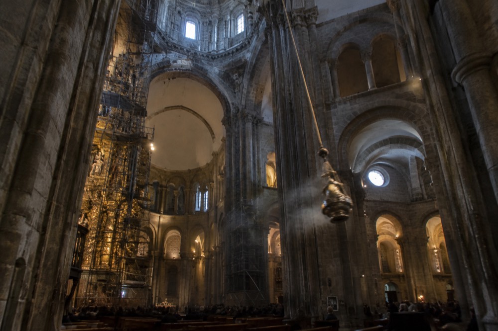 Restoration scaffolding rising inside a cathedral crossing beneath a stone lantern dome
