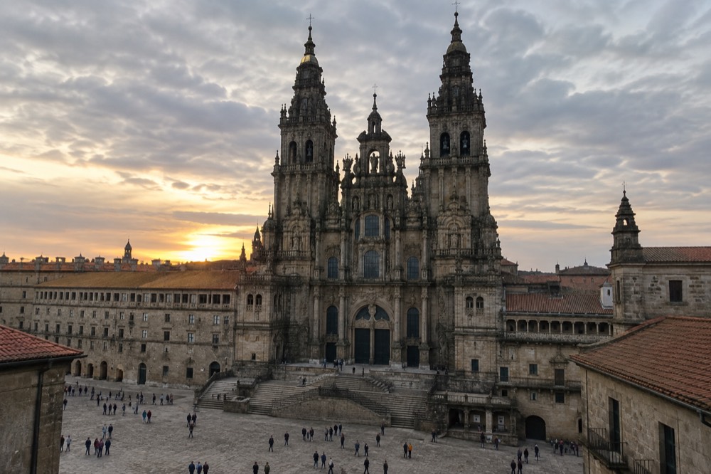 The baroque facade of Santiago de Compostela Cathedral rising above the arcaded square at dusk
