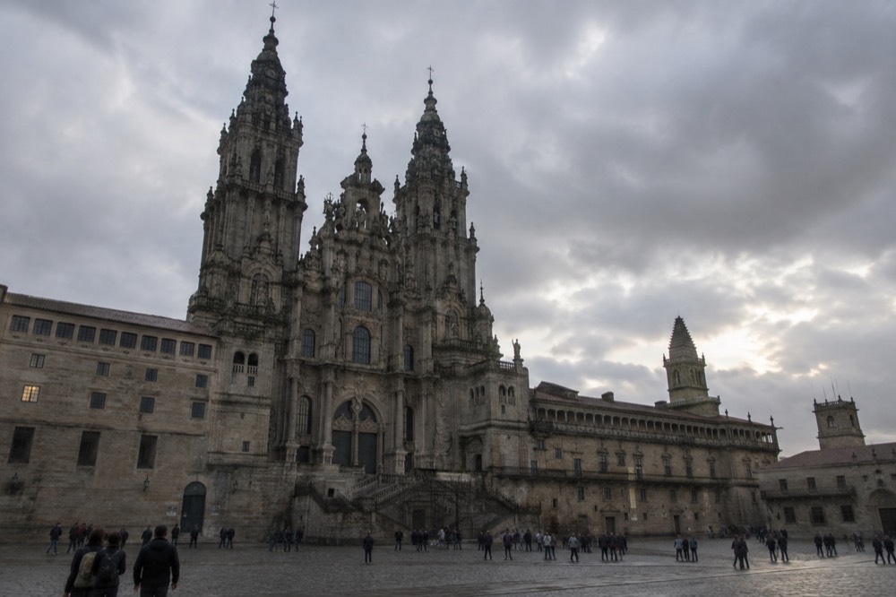 A wide view of Santiago de Compostela's cathedral towers and old rooftops under an evening sky