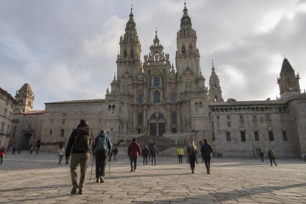 Tourists and pilgrims crossing Praza do Obradoiro toward the cathedral's Obradoiro facade