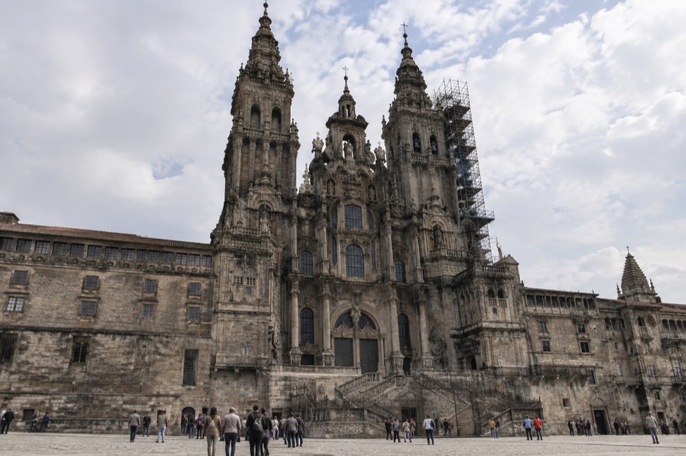 Stone masonry detail of the cathedral facade with conservation scaffolding visible on a tower
