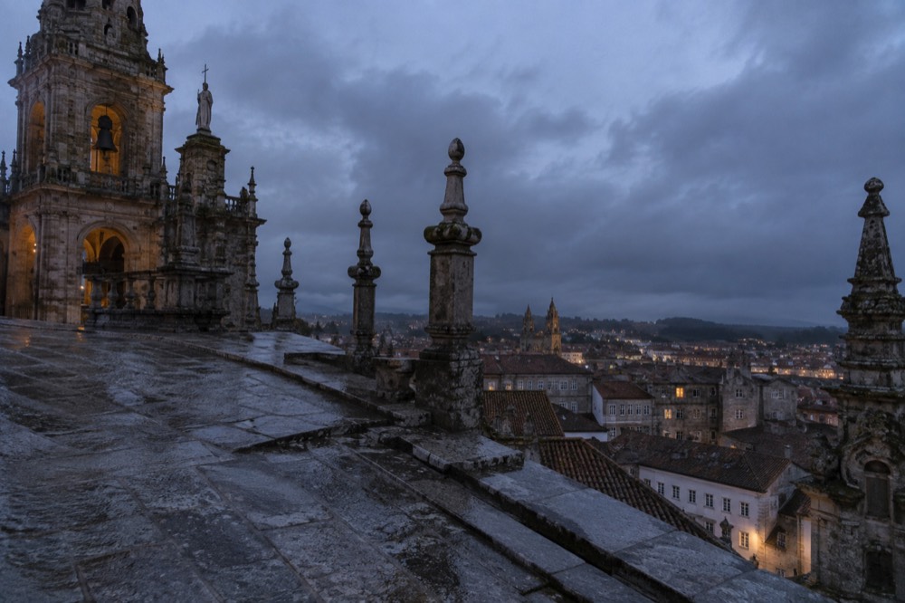 Rain-slicked granite paving and cathedral spires under a grey Galician sky