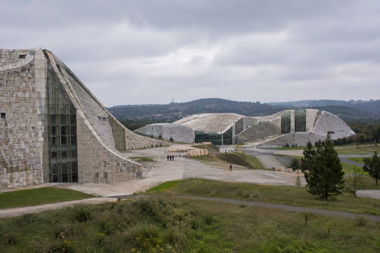 Modern stone buildings of the City of Culture complex on a green hillside above Santiago de Compostela