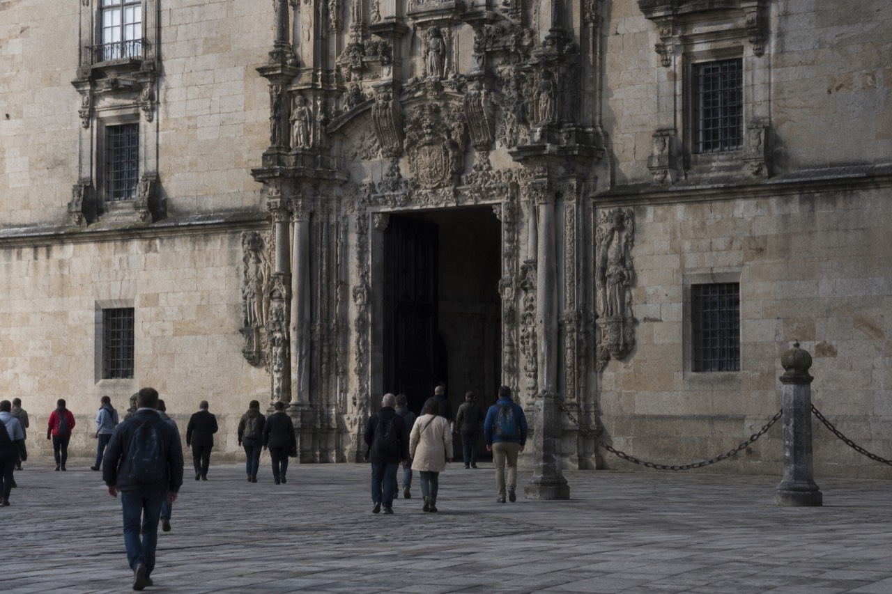 The carved Plateresque facade of the Hostal dos Reis Catolicos seen from the cathedral square