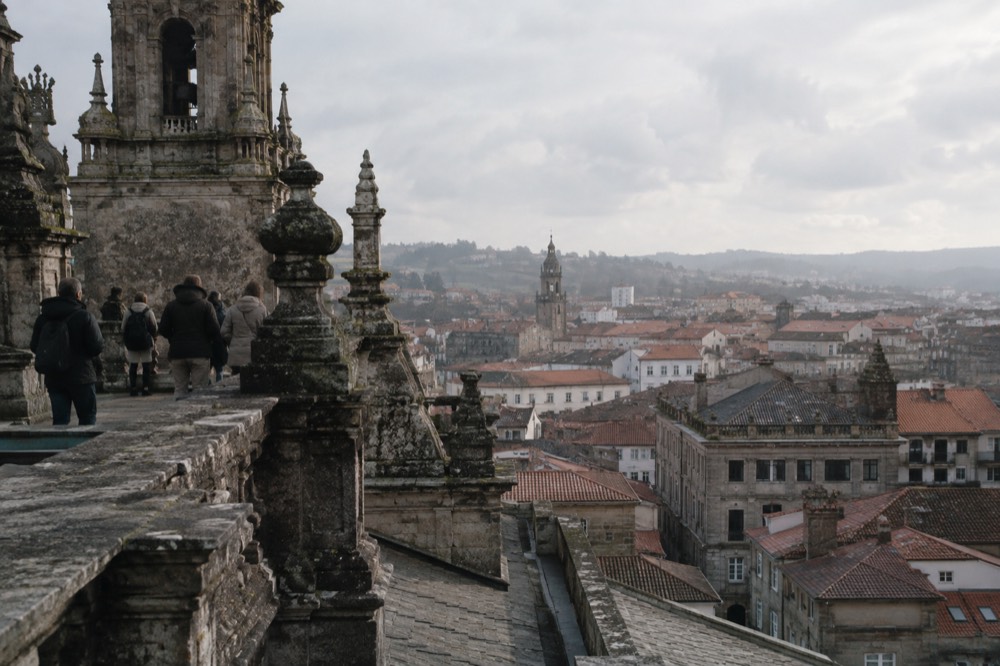 Visitors on the stone roofs of Santiago de Compostela Cathedral looking out over the old town rooftops