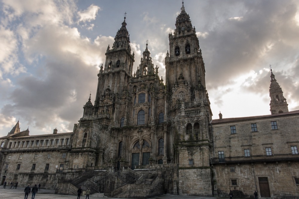 A quiet evening path across the hill with the lights of Santiago de Compostela beginning to appear below