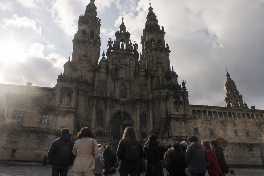 Tour group with a guide standing inside the nave of Santiago de Compostela Cathedral