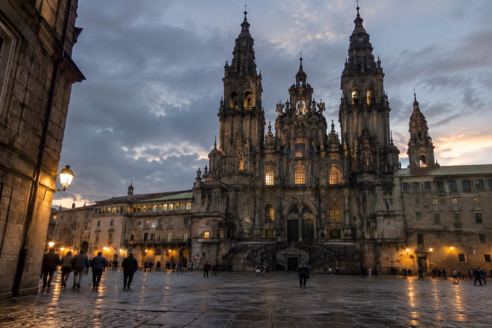 Evening view of a granite square in Santiago de Compostela old town with the Cathedral towers lit in the background