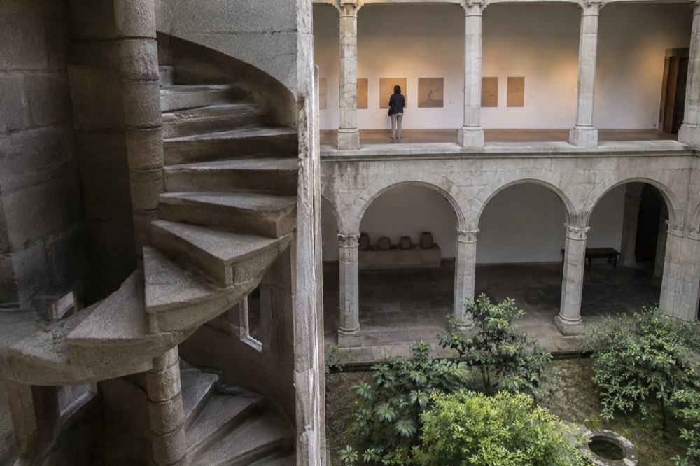 Visitor reading display panels in a bright gallery of the Museo do Pobo Galego