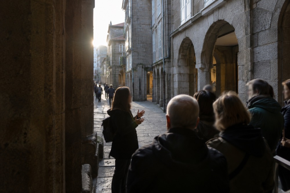 Guide speaking to a small group on a stone street in the old town of Santiago de Compostela
