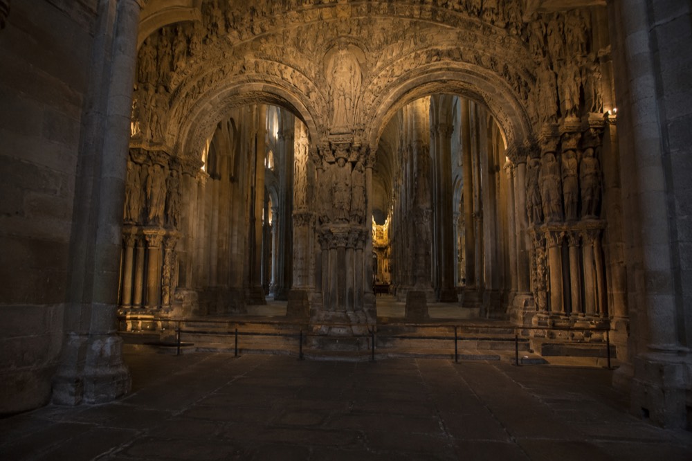 A wide view of the Portico da Gloria arches illuminated inside the Cathedral of Santiago de Compostela