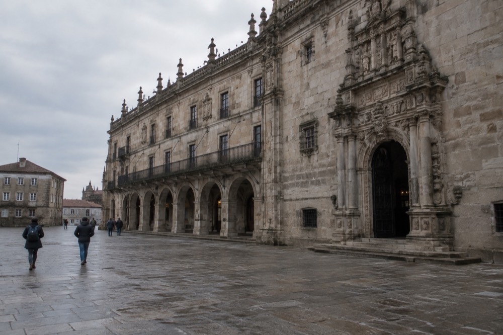The arcaded granite facade of the Hostal dos Reis Catolicos Parador on the north side of the square