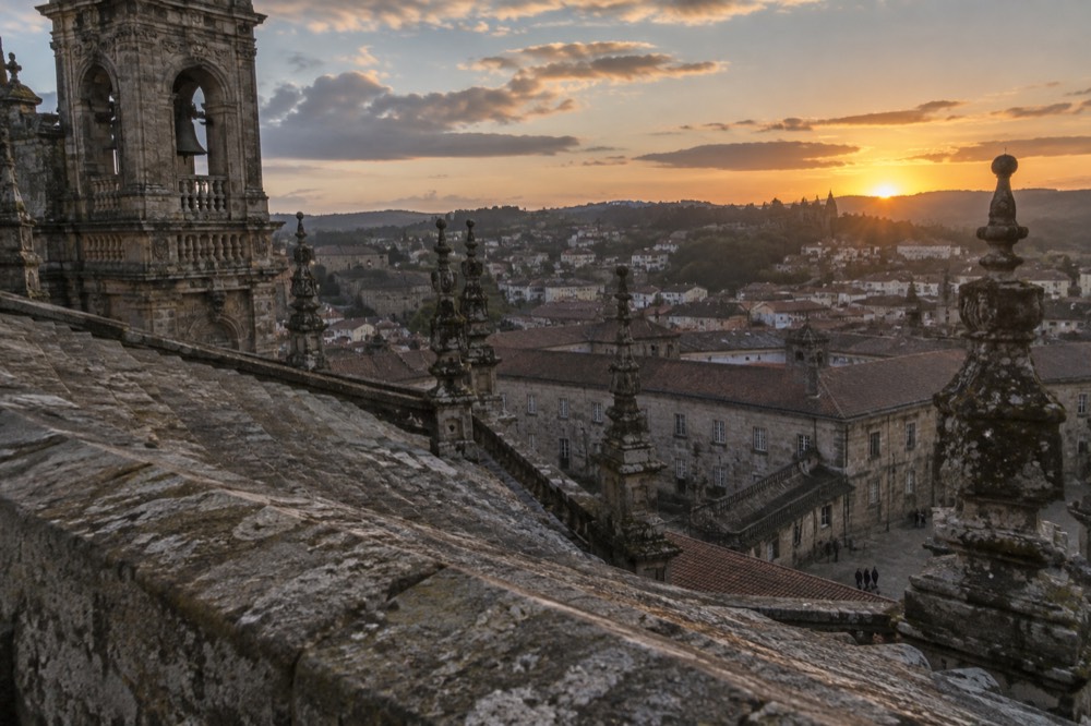 Sunset over the cathedral rooftops of Santiago de Compostela seen from a park viewpoint with the old town below