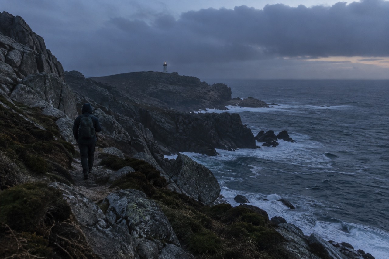 Rocky Atlantic cliffs with waves breaking against dark stone under a grey Galician sky