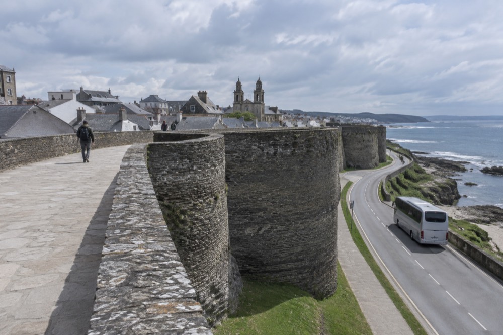 A touring coach parked on a coastal road above the sea in Galicia