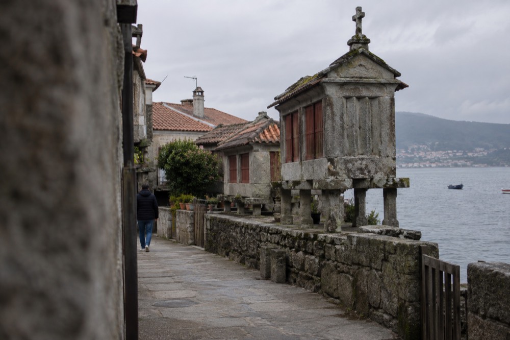 Granite granary storehouses on stone pillars standing along a waterfront in a small Galician fishing village