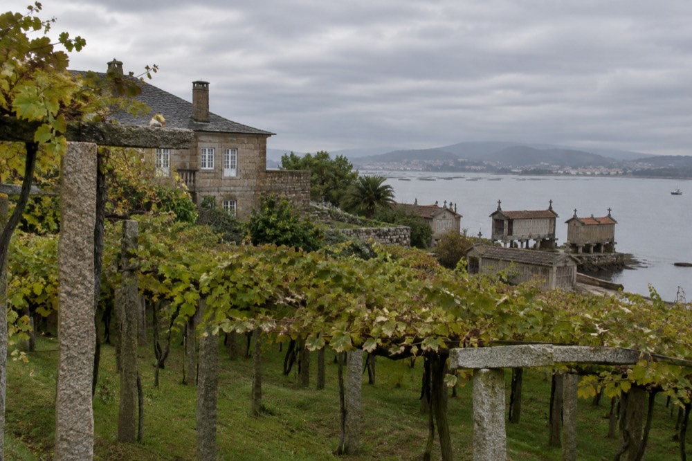 A stone waterfront village with raised granite granaries standing at the edge of the water.