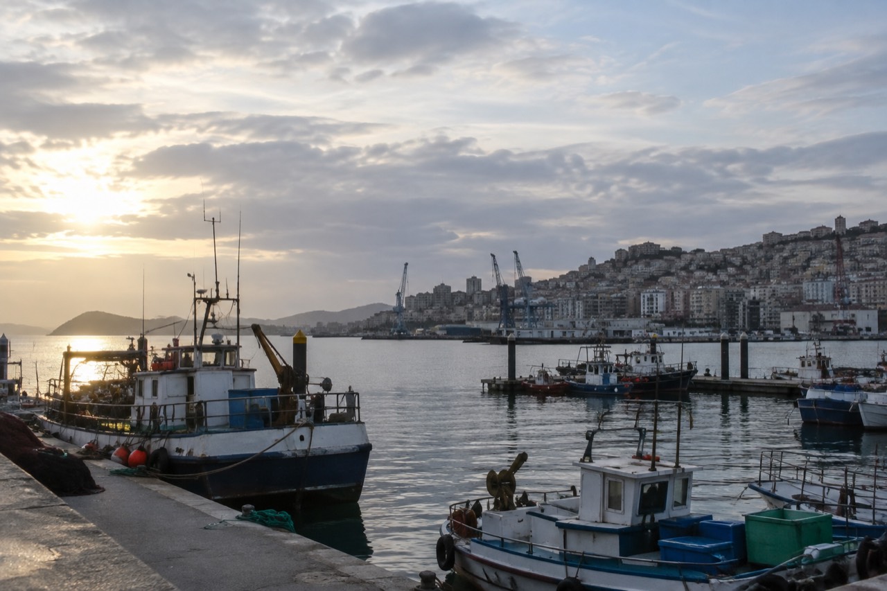 Fishing boats moored in Vigo harbor with the city rising on hills behind them
