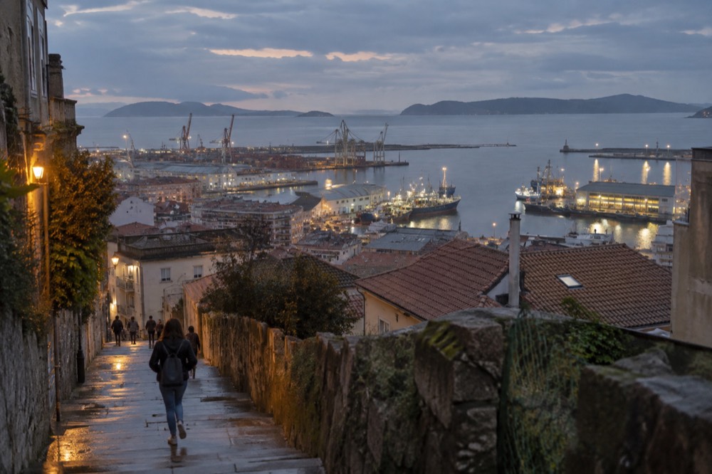 Evening view over Vigo harbor with fishing boats and city lights reflected in the water