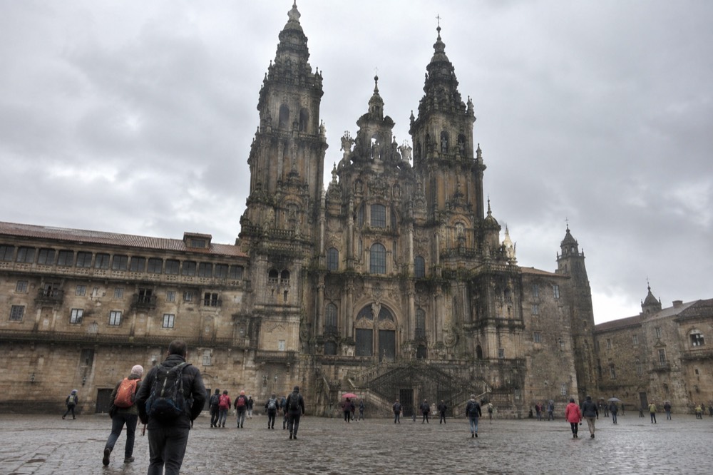 Pilgrims arriving in Praza do Obradoiro in front of the Cathedral of Santiago de Compostela
