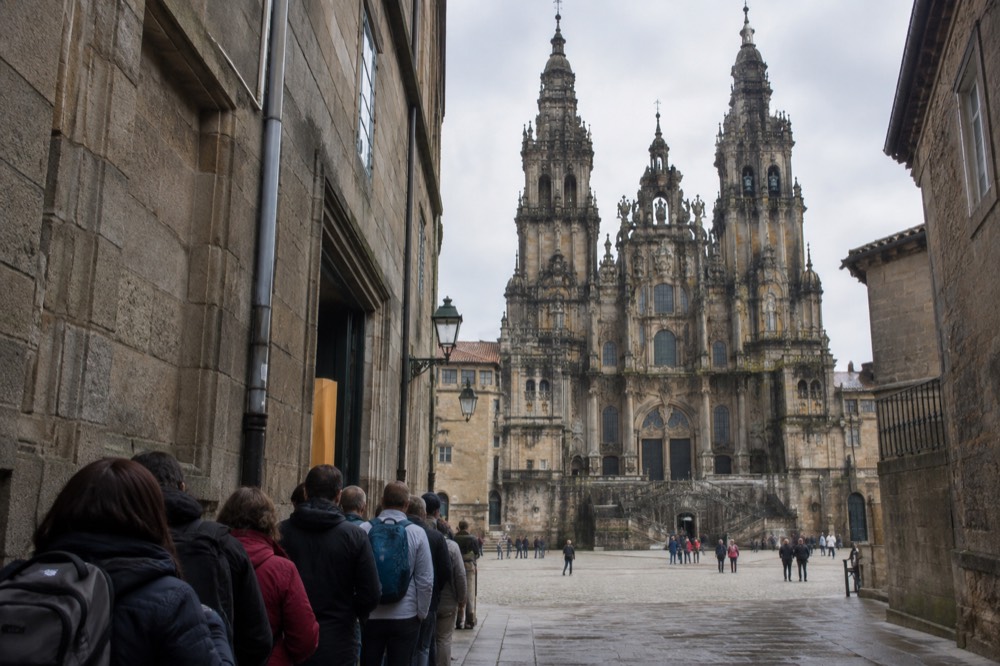 Pilgrims queueing at the Pilgrim's Office entrance on Rua das Carretas in Santiago de Compostela