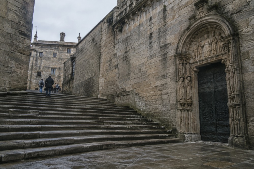 The carved stone Holy Door on the east side of a cathedral beside a broad granite square