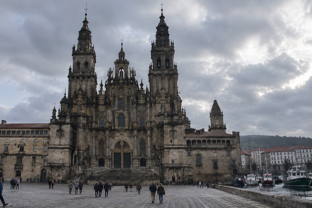 The harbor waterfront of Ferrol in Galicia with boats and stone buildings under an overcast sky