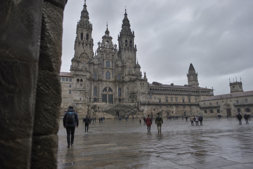 Walkers setting out from a small Galician town under morning mist