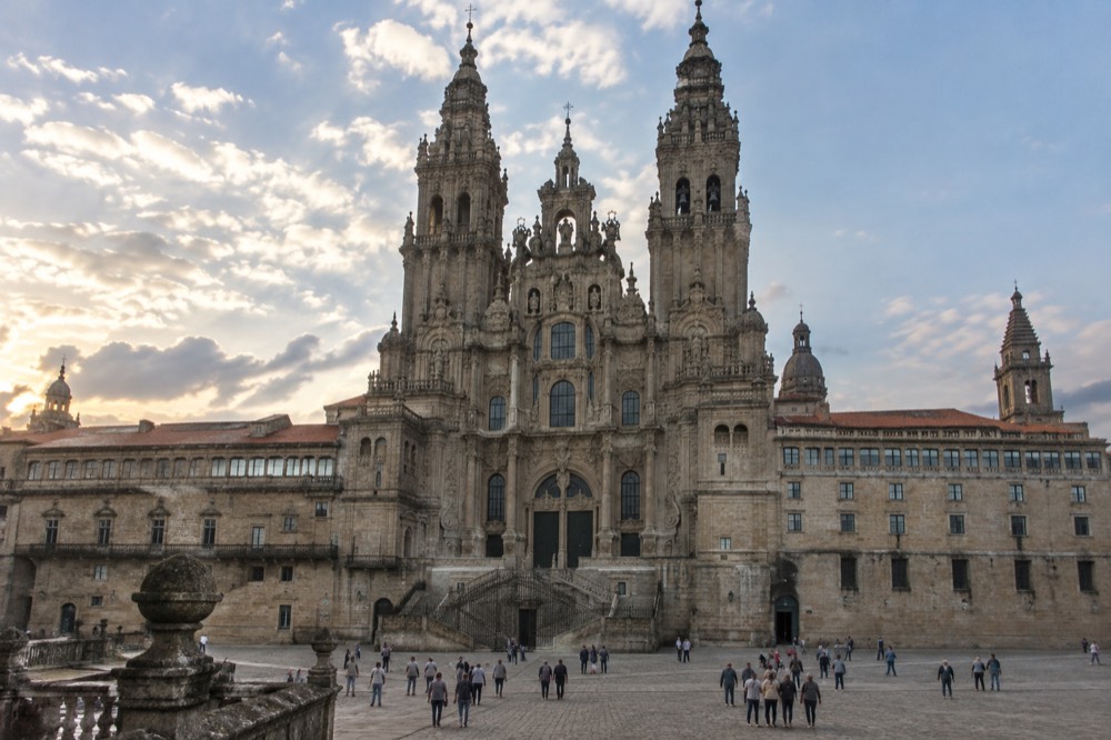 The stone rooftops and towers of Santiago de Compostela Cathedral seen from an upper terrace in evening light