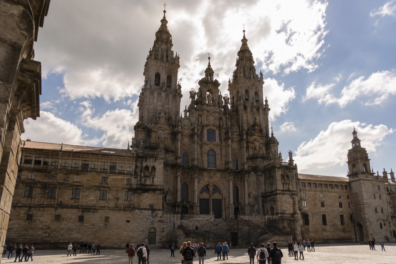 The baroque towers of Santiago de Compostela Cathedral rising above the stone square of Obradoiro in evening light