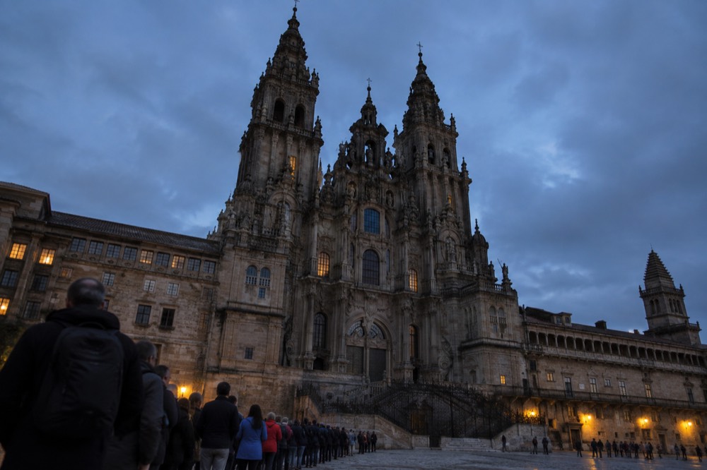 Pilgrims queueing with credential documents outside the pilgrim office in Santiago de Compostela