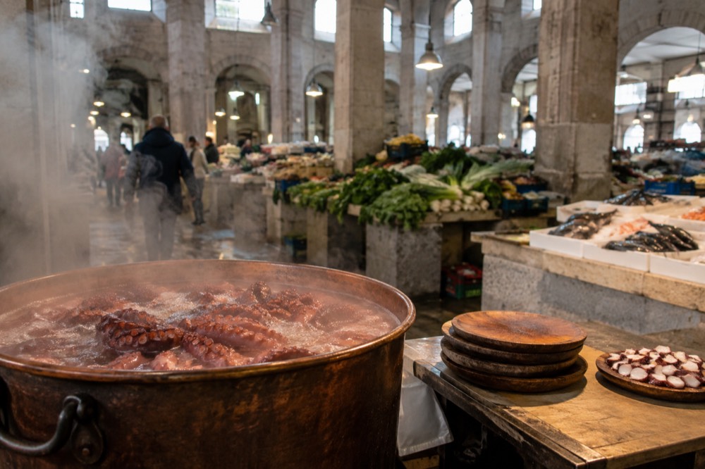 A copper pot of boiling octopus at an outdoor Galician fair stall