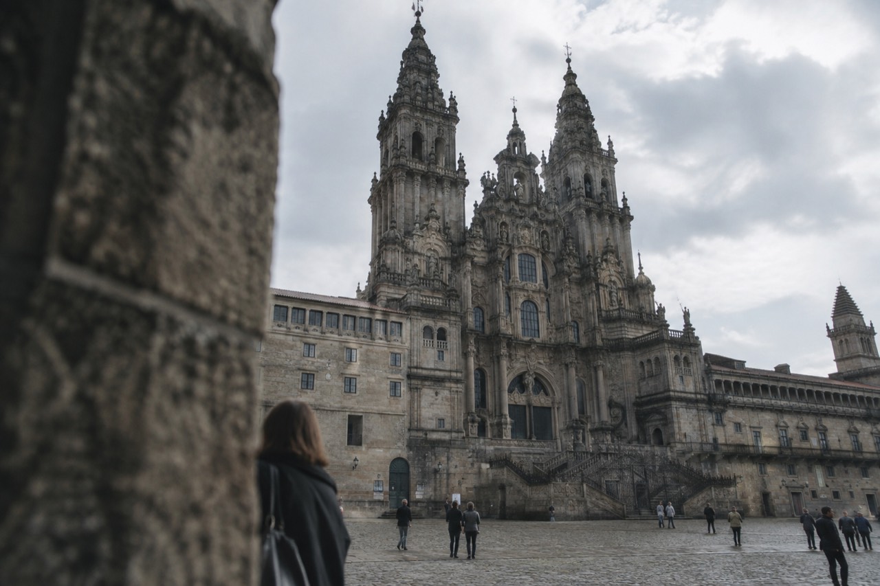Illuminated facade of Santiago de Compostela Cathedral at night seen from the square