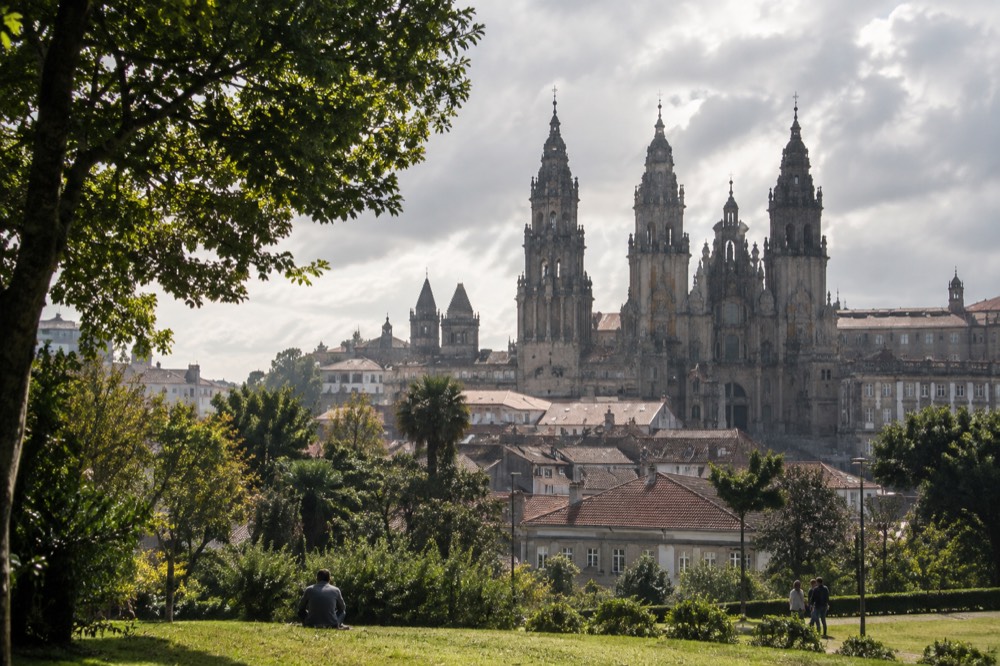Morning view over rooftops and the cathedral towers from a green park slope