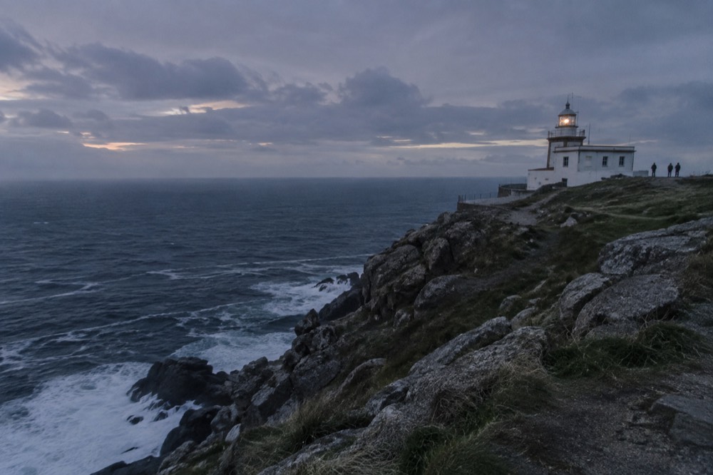 Atlantic waves breaking against the rocky lighthouse point at Fisterra on the Costa da Morte