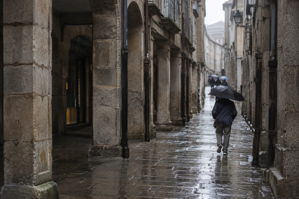 Rain-washed granite streets glistening in Santiago de Compostela old town under an overcast sky