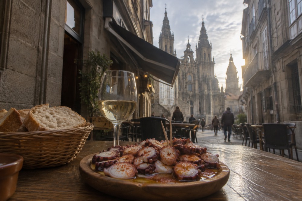 A plate of sliced octopus with paprika and olive oil served on a rustic wooden dish