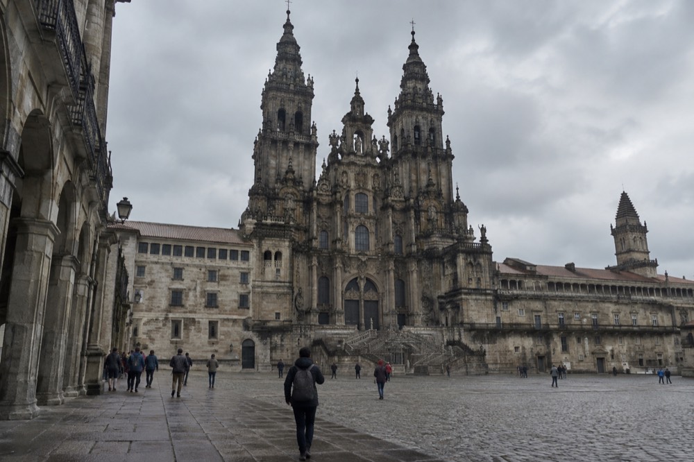 Walking tour group paused under the arcades beside the Cathedral's Baroque towers