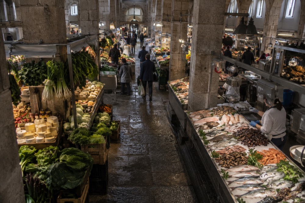 Stalls of greens, cheese and fresh fish inside a Galician market hall