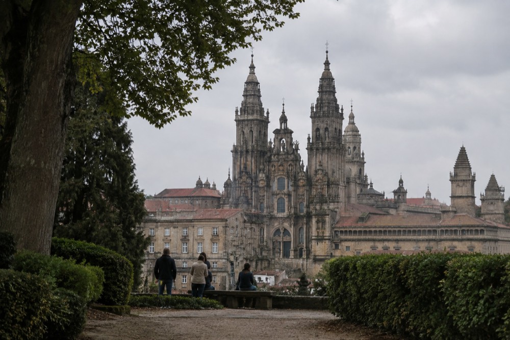 Viewers on a park path looking toward the Cathedral skyline from the Alameda