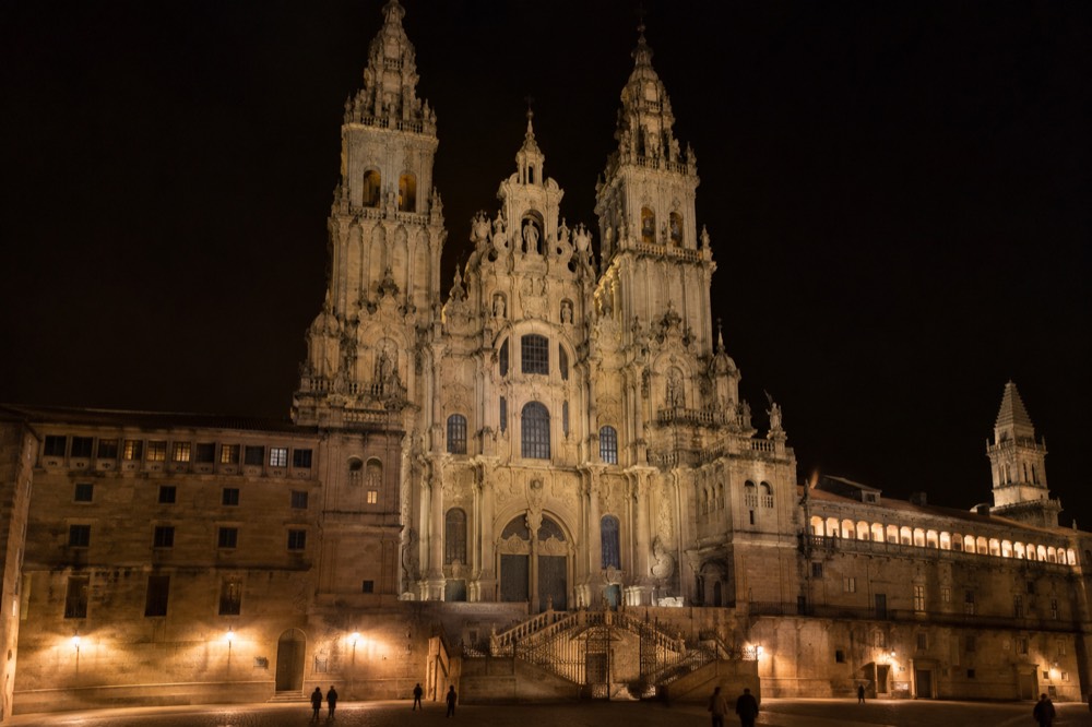 Floodlit baroque towers of the Cathedral seen from a dark square at night