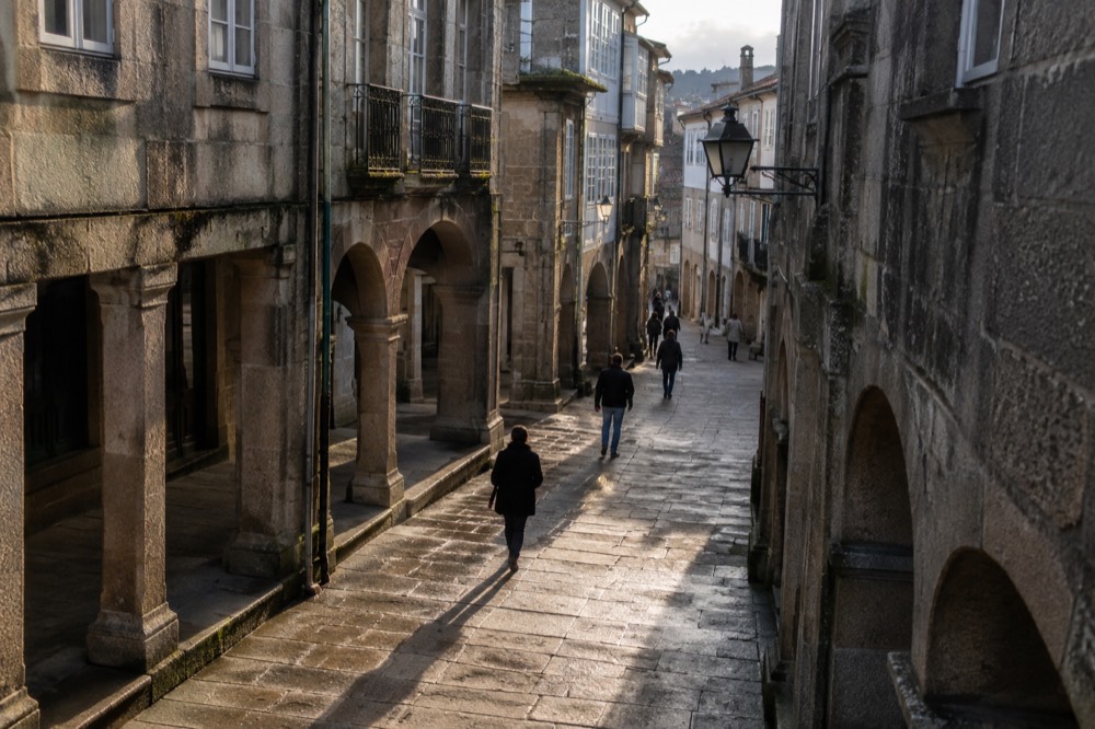 A narrow granite-paved lane with arcades in the Old Town of Santiago de Compostela