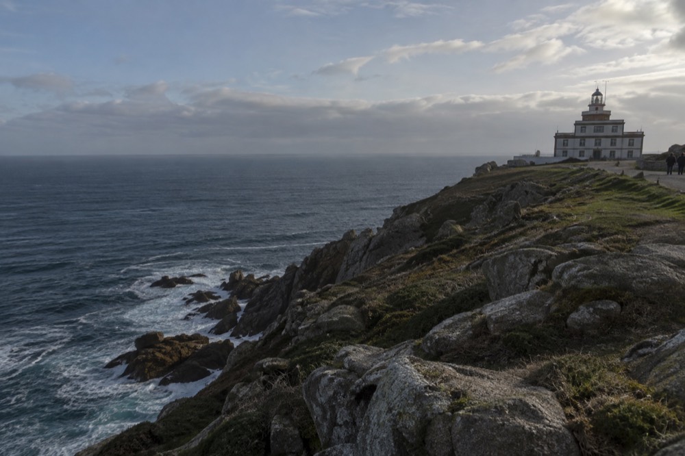 Waves breaking against granite cliffs at the Fisterra lighthouse on the Costa da Morte