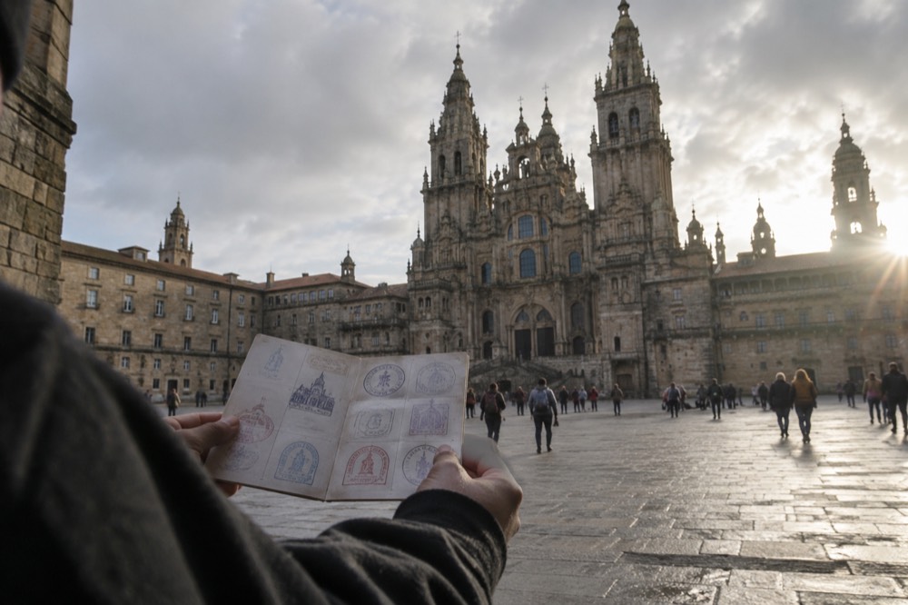 A credencial pilgrim passport held open showing Camino de Santiago stamps