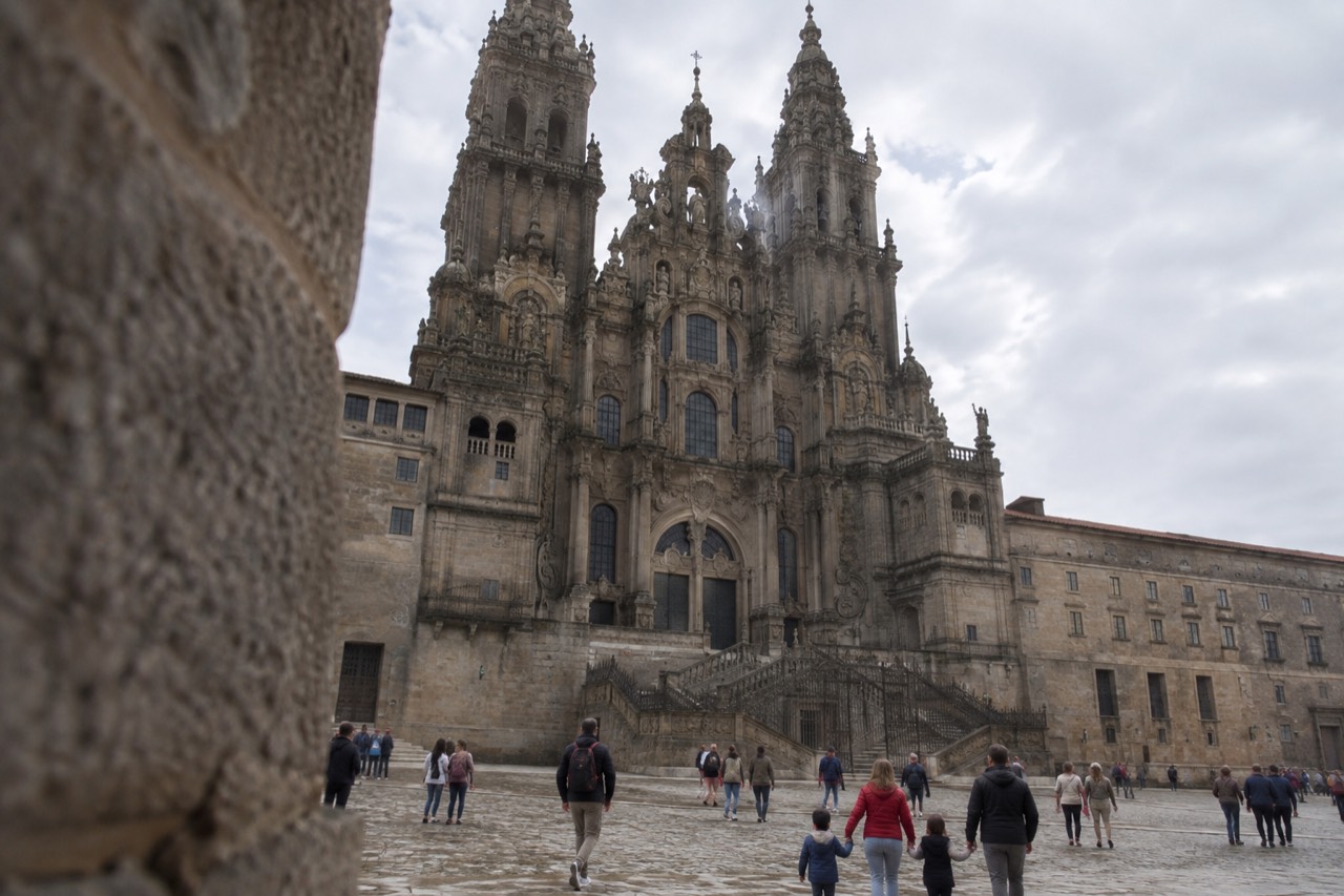 Families with children walking across the granite square in front of Santiago de Compostela Cathedral